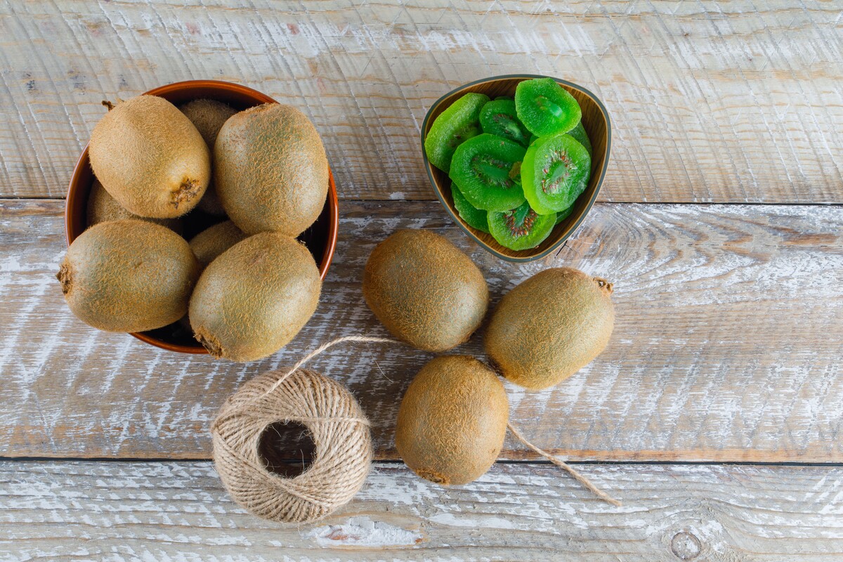 kiwi bowl with dried slices thread ball flat lay wooden table