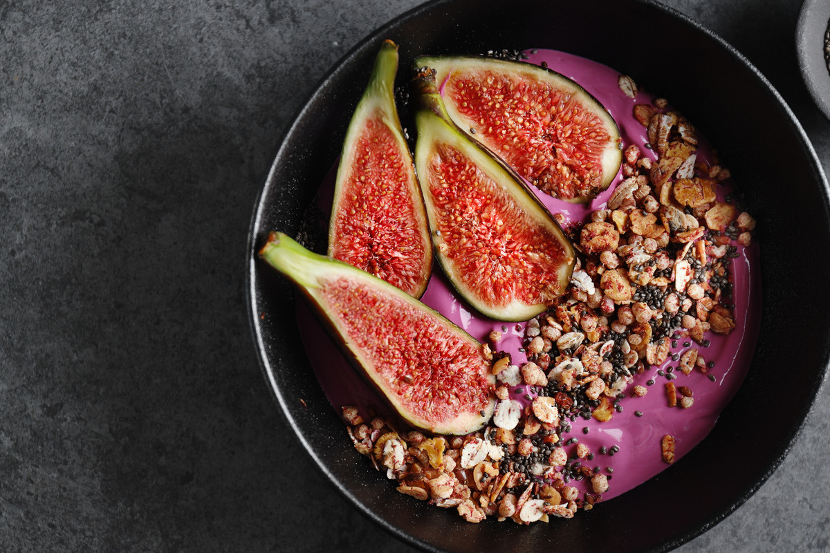 Fruity bowl with muesli granola and figs served in bowl. 